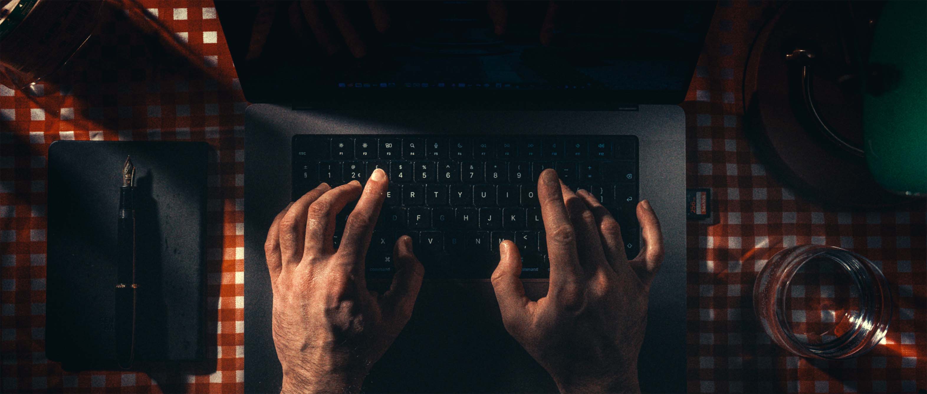 Hands typing at a wooden writer's desk